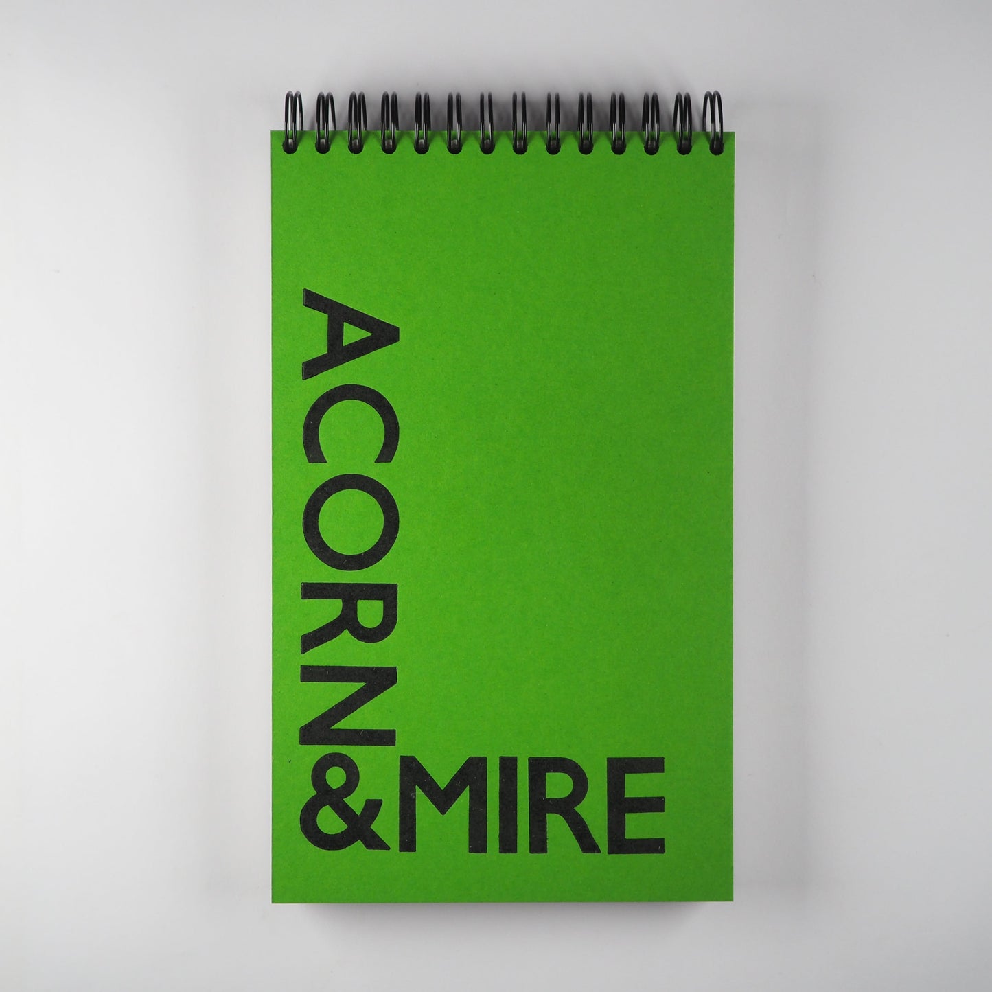 wirebound journal with Acorn & Mire printed with wood type in black on a green cover - Devon theme